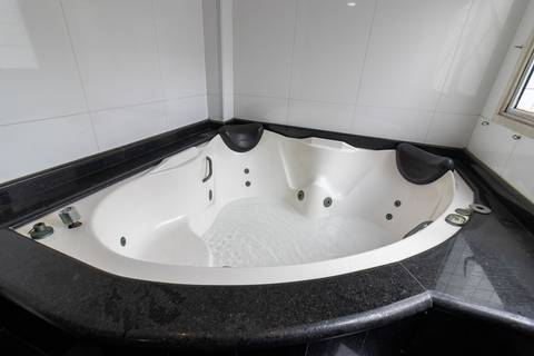 Fotografia profissional de uma cobertura no bairro Canto do Forte, em Praia Grande, SP, pelo fotógrafo profissional de imóveis Fernando Freire, foto para anúncio de apartamento no Airbnb e QuintoAndar. Ambiente da terceira suíte com banheira e armário.'