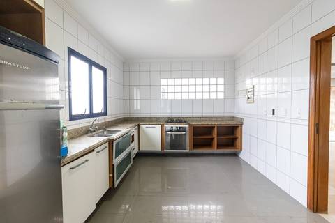 Fotografia profissional de uma cobertura no bairro Canto do Forte, em Praia Grande, SP, pelo fotógrafo profissional de imóveis Fernando Freire, foto para anúncio de apartamento no Airbnb e QuintoAndar. Ambiente da cozinha planejada e com eletrodomésticos.'
