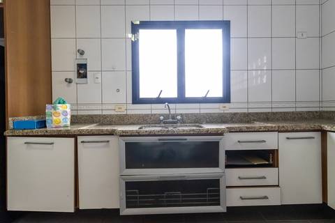 Fotografia profissional de uma cobertura no bairro Canto do Forte, em Praia Grande, SP, pelo fotógrafo profissional de imóveis Fernando Freire, foto para anúncio de apartamento no Airbnb e QuintoAndar. Ambiente da cozinha planejada e com eletrodomésticos.'
