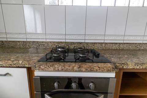 Fotografia profissional de uma cobertura no bairro Canto do Forte, em Praia Grande, SP, pelo fotógrafo profissional de imóveis Fernando Freire, foto para anúncio de apartamento no Airbnb e QuintoAndar. Ambiente da cozinha planejada e com eletrodomésticos.'