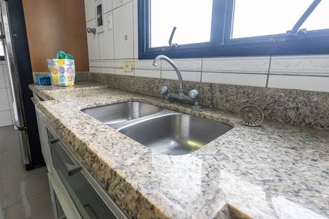 Fotografia profissional de uma cobertura no bairro Canto do Forte, em Praia Grande, SP, pelo fotógrafo profissional de imóveis Fernando Freire, foto para anúncio de apartamento no Airbnb e QuintoAndar. Ambiente da cozinha planejada e com eletrodomésticos.'