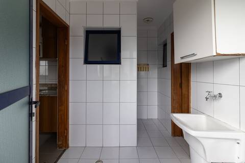 Fotografia profissional de uma cobertura no bairro Canto do Forte, em Praia Grande, SP, pelo fotógrafo profissional de imóveis Fernando Freire, foto para anúncio de apartamento no Airbnb e QuintoAndar. Ambiente da área de serviço com quarto e banheiro.'