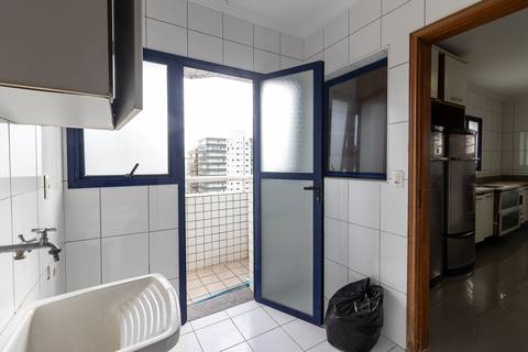 Fotografia profissional de uma cobertura no bairro Canto do Forte, em Praia Grande, SP, pelo fotógrafo profissional de imóveis Fernando Freire, foto para anúncio de apartamento no Airbnb e QuintoAndar. Ambiente da área de serviço com quarto e banheiro.'