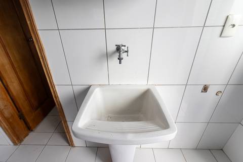 Fotografia profissional de uma cobertura no bairro Canto do Forte, em Praia Grande, SP, pelo fotógrafo profissional de imóveis Fernando Freire, foto para anúncio de apartamento no Airbnb e QuintoAndar. Ambiente da área de serviço com quarto e banheiro.'