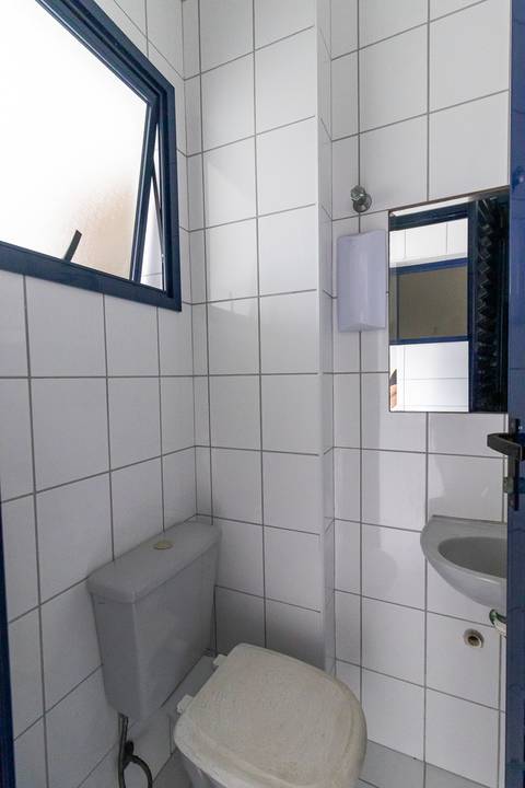 Fotografia profissional de uma cobertura no bairro Canto do Forte, em Praia Grande, SP, pelo fotógrafo profissional de imóveis Fernando Freire, foto para anúncio de apartamento no Airbnb e QuintoAndar. Ambiente da área de serviço com quarto e banheiro.'