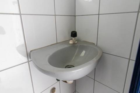 Fotografia profissional de uma cobertura no bairro Canto do Forte, em Praia Grande, SP, pelo fotógrafo profissional de imóveis Fernando Freire, foto para anúncio de apartamento no Airbnb e QuintoAndar. Ambiente da área de serviço com quarto e banheiro.'