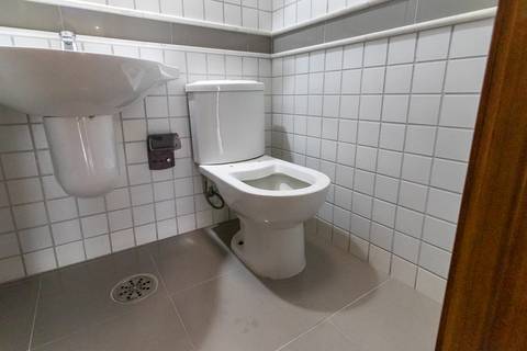 Fotografia profissional de uma cobertura no bairro Canto do Forte, em Praia Grande, SP, pelo fotógrafo profissional de imóveis Fernando Freire, foto para anúncio de apartamento no Airbnb e QuintoAndar. Ambiente da área de serviço com quarto e banheiro.'