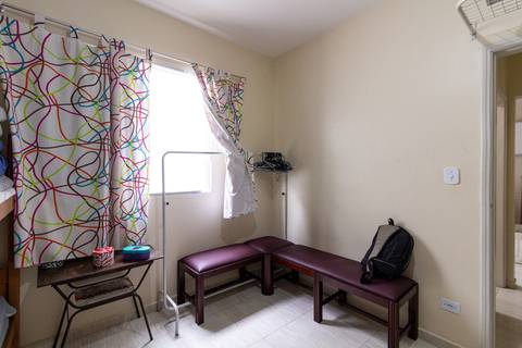 Fotografia Imobiliária profissional no bairro Vila Caiçara, feita por Fernando Freire, fotógrafo de imóveis na Praia Grande e Baixada Santista. Foto para anúncio em Airbnb do quarto do apartamento mobiliado completa.'