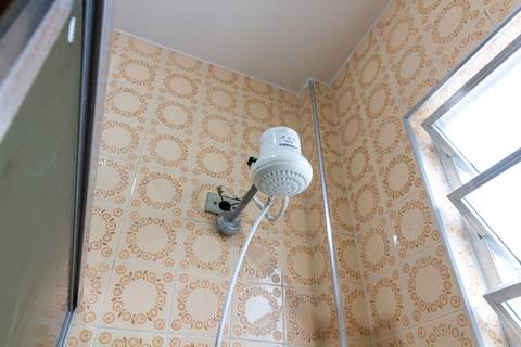 Fotografia Imobiliária profissional no bairro Vila Caiçara, feita por Fernando Freire, fotógrafo de imóveis na Praia Grande e Baixada Santista. Foto para anúncio em Airbnb do banheiro do apartamento mobiliado completa.'