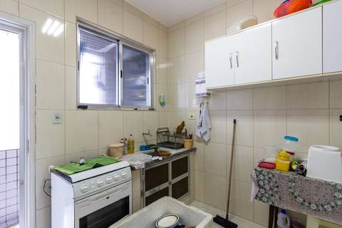 Fotografia Imobiliária profissional no bairro Vila Caiçara, feita por Fernando Freire, fotógrafo de imóveis na Praia Grande e Baixada Santista. Foto para anúncio em Airbnb da cozinha do apartamento mobiliado completa.'