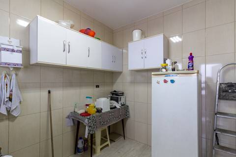 Fotografia Imobiliária profissional no bairro Vila Caiçara, feita por Fernando Freire, fotógrafo de imóveis na Praia Grande e Baixada Santista. Foto para anúncio em Airbnb da cozinha do apartamento mobiliado completa.'