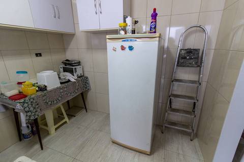 Fotografia Imobiliária profissional no bairro Vila Caiçara, feita por Fernando Freire, fotógrafo de imóveis na Praia Grande e Baixada Santista. Foto para anúncio em Airbnb da cozinha do apartamento mobiliado completa.'