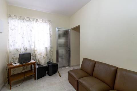 Fotografia Imobiliária profissional no bairro Vila Caiçara, feita por Fernando Freire, fotógrafo de imóveis na Praia Grande e Baixada Santista. Foto para anúncio em Airbnb da sala do apartamento mobiliado completa.'