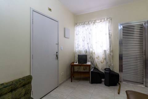 Fotografia Imobiliária profissional no bairro Vila Caiçara, feita por Fernando Freire, fotógrafo de imóveis na Praia Grande e Baixada Santista. Foto para anúncio em Airbnb da sala do apartamento mobiliado completa.'