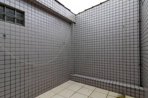 Fotografia Imobiliária profissional no bairro Vila Caiçara, feita por Fernando Freire, fotógrafo de imóveis na Praia Grande e Baixada Santista. Foto para anúncio em Airbnb do quintal do apartamento mobiliado completa.'