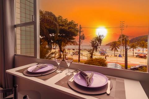 Vista para o mar em apartamento em São Vicente, com destaque para o pôr do sol – fotografia imobiliária para Airbnb e Booking.'