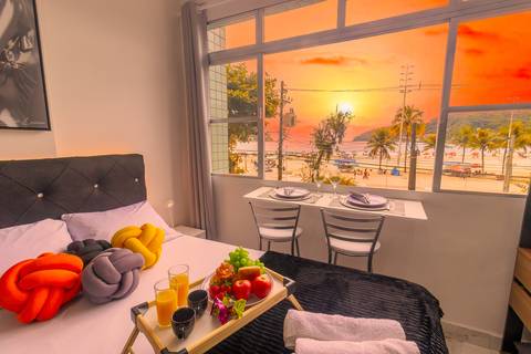 Vista para o mar em apartamento em São Vicente, com destaque para o pôr do sol – fotografia imobiliária para Airbnb e Booking.'