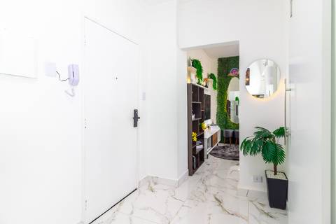 Sala de jantar integrada com decoração moderna em apartamento para locação de temporada em São Vicente – fotografia imobiliária.'