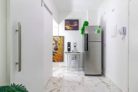 Sala de jantar integrada com decoração moderna em apartamento para locação de temporada em São Vicente – fotografia imobiliária.'