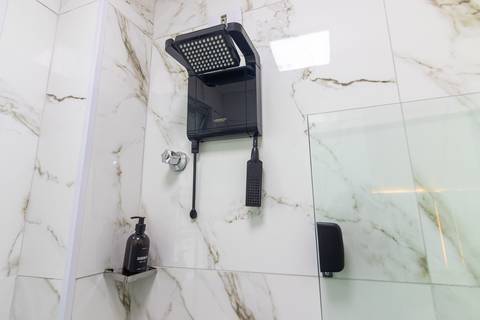 Banheiro moderno e bem iluminado em apartamento mobiliado para temporada – fotografia imobiliária em São Vicente.'