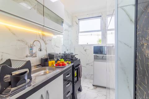 Cozinha completa e equipada em apartamento para Airbnb em São Vicente – fotografia imobiliária profissional.'