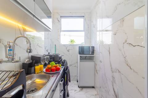 Cozinha completa e equipada em apartamento para Airbnb em São Vicente – fotografia imobiliária profissional.'
