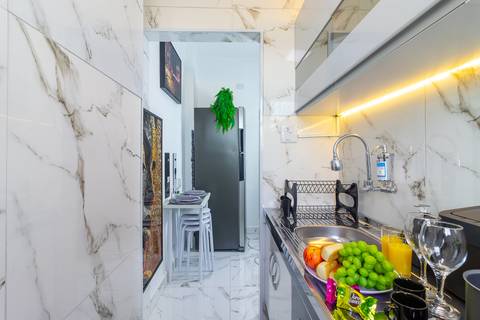 Cozinha completa e equipada em apartamento para Airbnb em São Vicente – fotografia imobiliária profissional.'