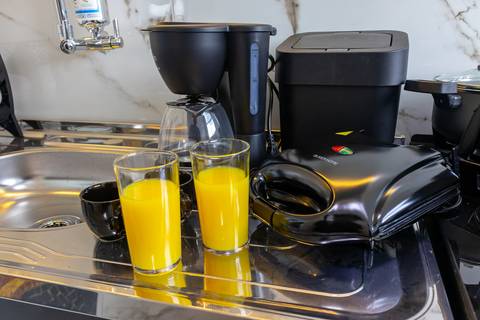 Cozinha completa e equipada em apartamento para Airbnb em São Vicente – fotografia imobiliária profissional.'