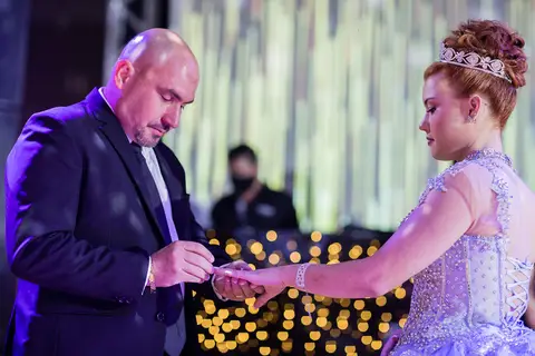 pai colocando aliança no dedo da debutante logo após a dança '