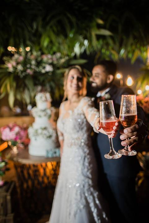 hora do brinde dos noivos noiva e noivo na mesa de bolo noiva linda com buque flores rosa lindo '