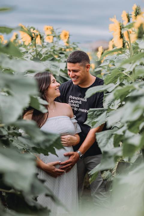 casal em meio a plantacao girasol se olhando'