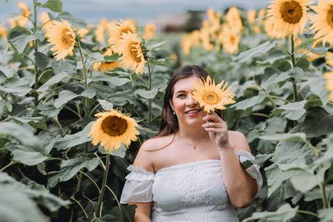 gestante segurando flor de girasol'