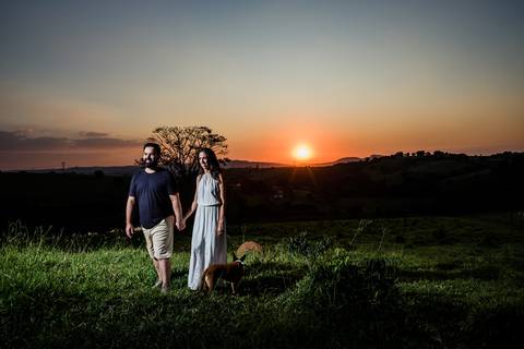 casal caminhando com por do sol ao fundo'