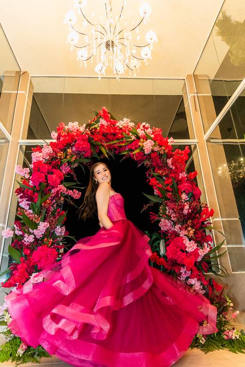 sentada numa guirlanda de flores girando vestido rosa lindo'