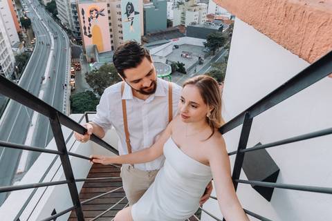 casal em escada cm cidade ao fundo'