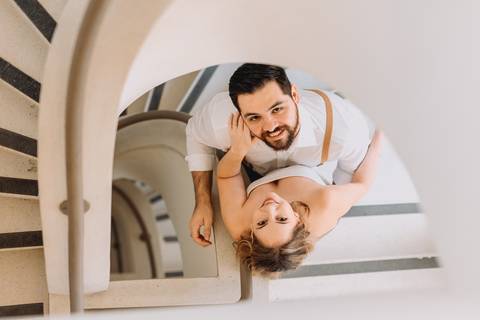 casal se olhando com escada caracol al lado'