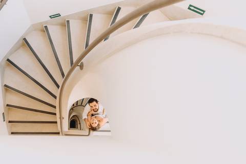 casal se olhando com escada caracol al lado'