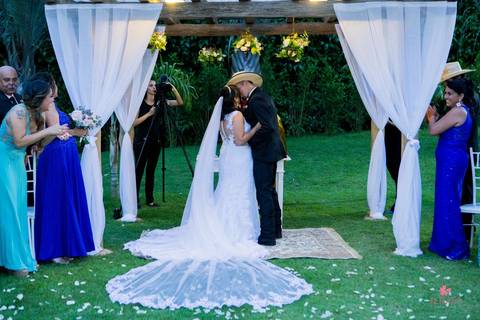 beijo no altar casamento no campo noivo de chapeu'