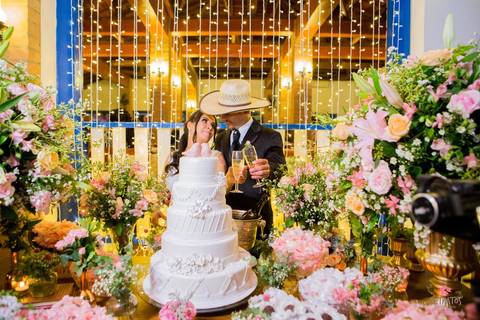 noivo chapeu abrindo champagne mesa do bolo'