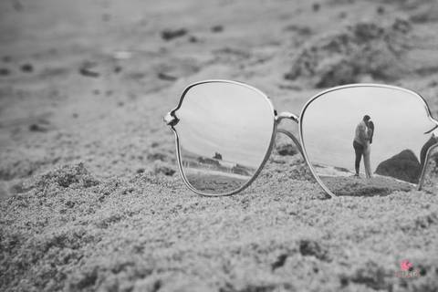 ensaio casal guaruja sp litoral norte pre wedding retratos itatiba julio akio hida fotografo foto praia interior sp campo brasil foto criativa  foto do óculos da noiva que é espelhado na areia pegando o reflexo deles na areia se beijando '