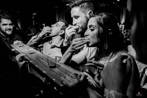 foto de tres pessoas bebendo tequila na regua, bastão de madeira com 3 copos encaixados '