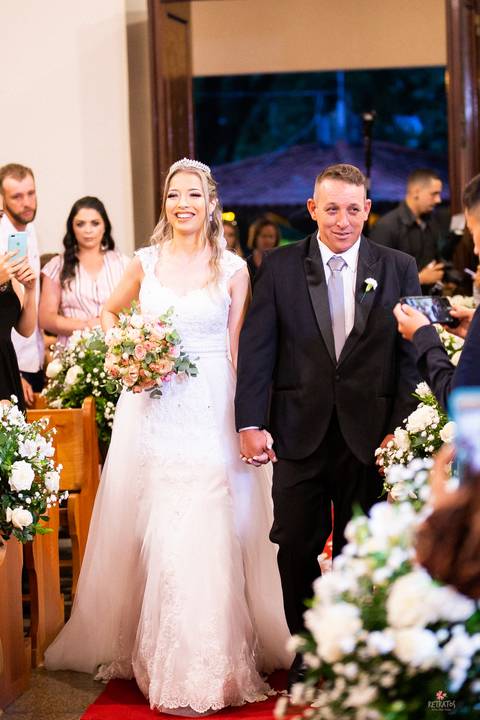 noiva entrando com pai e sorrindo'