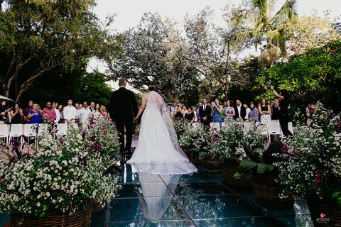 noiva entrando linda, pai do lado esquerdo dela e buque rosa cerimonia por do sol linda vestido de costas'