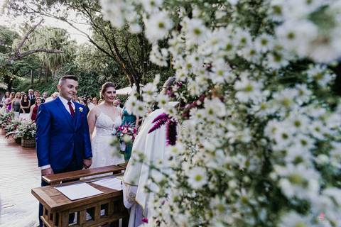 noivo recebendo noiva com beijo na testa noiva entrando linda, pai do lado esquerdo dela e buque rosa cerimonia por do sol linda '