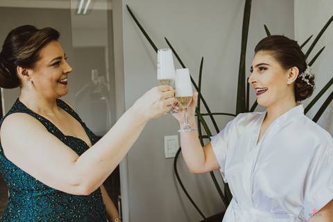 mãe e filha brindando durante a make antes do casamento'