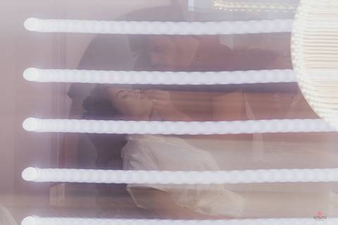 foto da noiva sendo maquiada frente espelho'