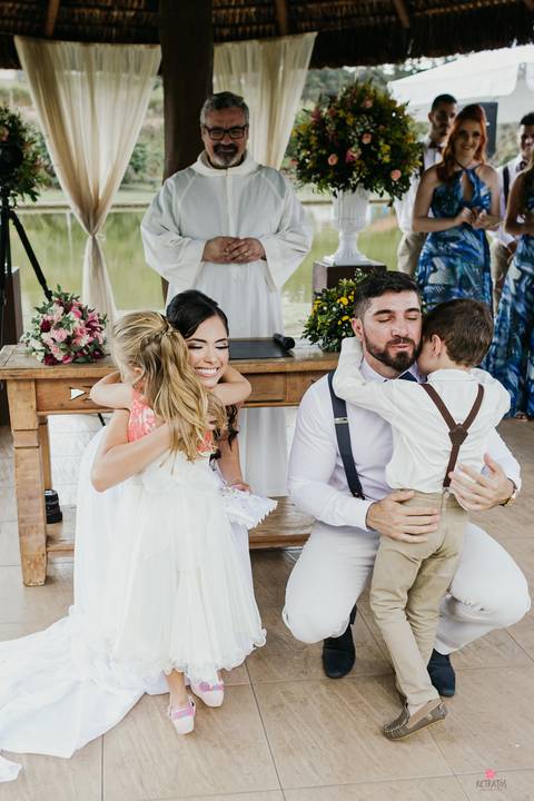 noivinhos abraçando o casal de noivos ao entregaram as alianças'