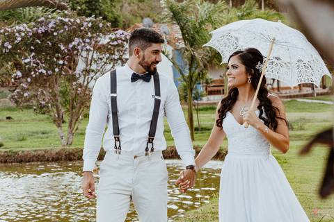 noivos caminhando e se olhando, noiva com sombrinha branca toda rendada'