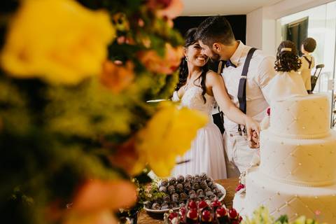 casal entre flores e bolo fake, detalhes de doce na mesa de bolo rustica detalhes de acessorios noiva lindo casamento interior sp itatiba interior fotografo de casamento'