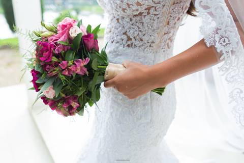 noiva entrando no carro com buque em mãos'